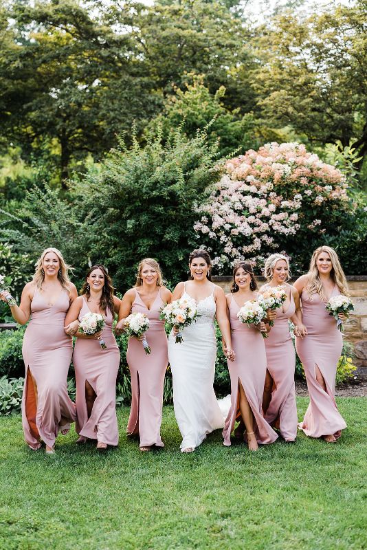 Bride and bridesmaids walk together at a summer Pittsburgh Botanic Garden wedding
