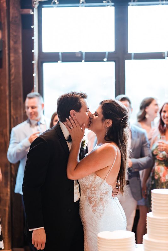 Bride and groom share kiss after cutting their cake at Summer Pittsburgh Botanic Garden wedding