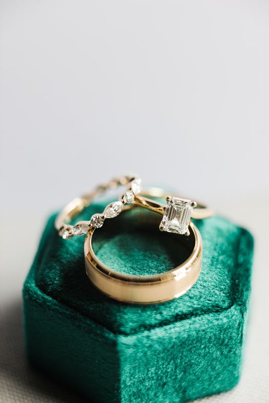 hunter green ring box with gold band and diamond engagement ring