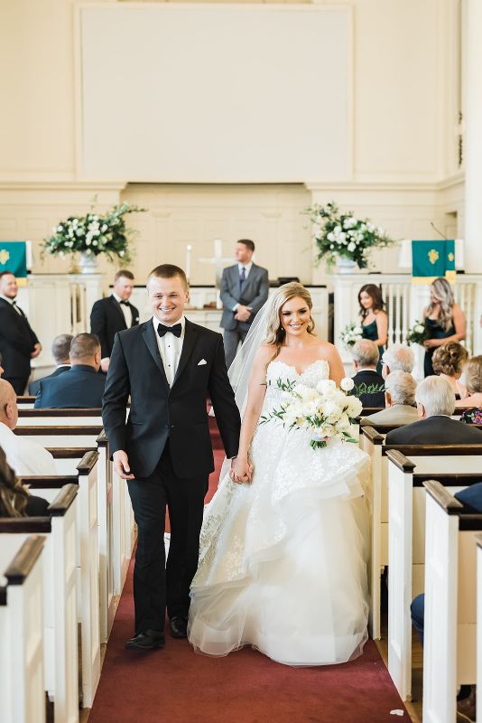 Bride and groom smile as they exit their wedding ceremony
