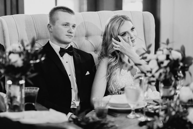 Bride and groom listen to speeches at summertime Grayson House wedding