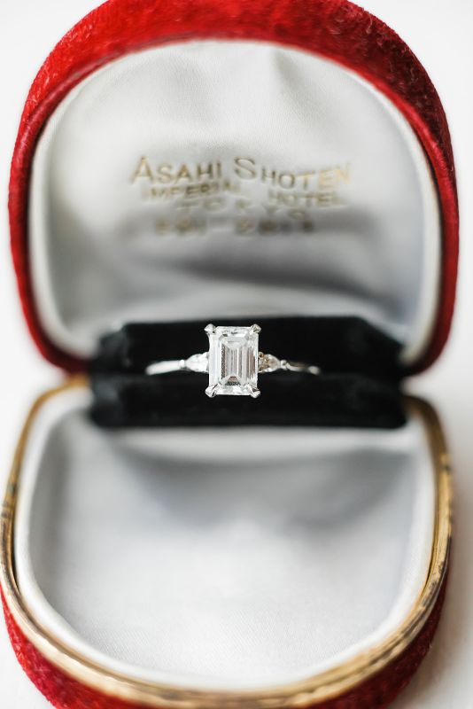 Macro photo of emerald cut engagement ring in red ring box