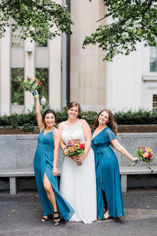 Bride and bridesmaids standing together in Mellon Park