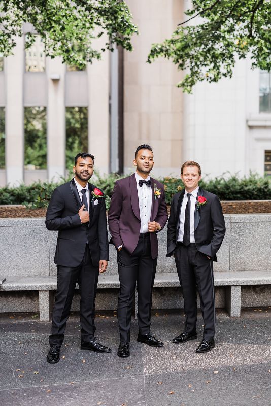 Groom poses with two groomsmen In Mellon Park 
