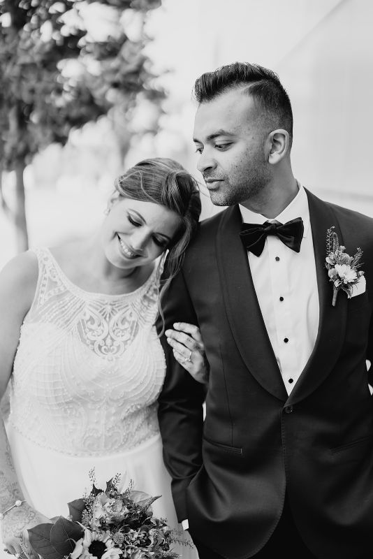Black and white photo of bride and groom smile together 