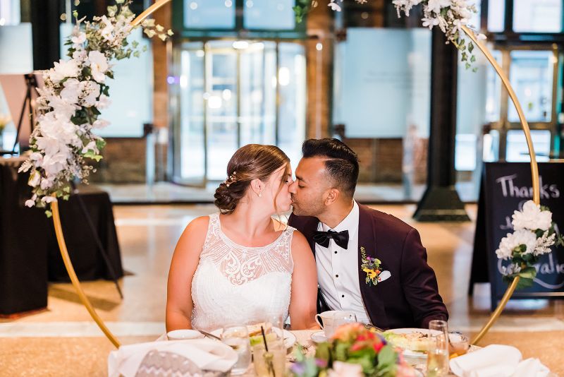 Bride and groom kiss at the sweetheart table at Heinz History Center wedding