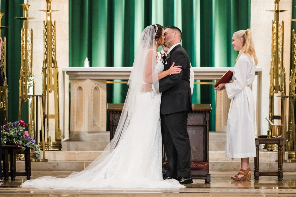 Bride and groom share their first kiss together 