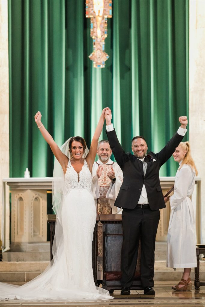 Bride and groom celebrate with triumph as they are announced as husband and wife