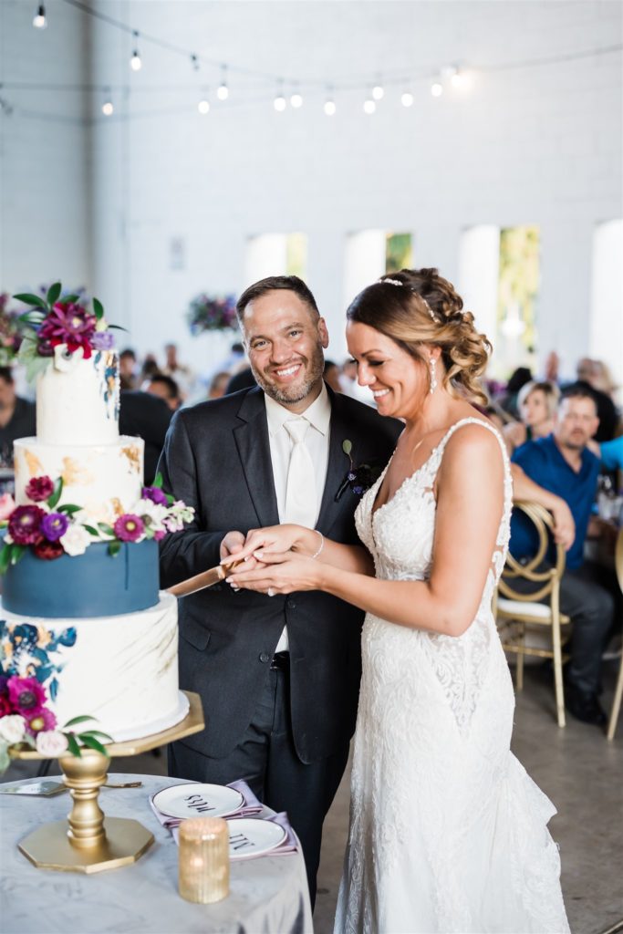 Bride and Groom cut their cake at summertime Aspinwall Riverfront Park Wedding
