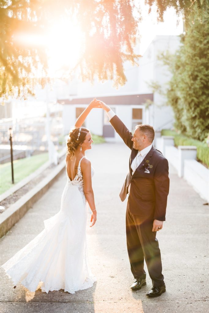 Groom spins bride near the Aspinwall Riverfront Park