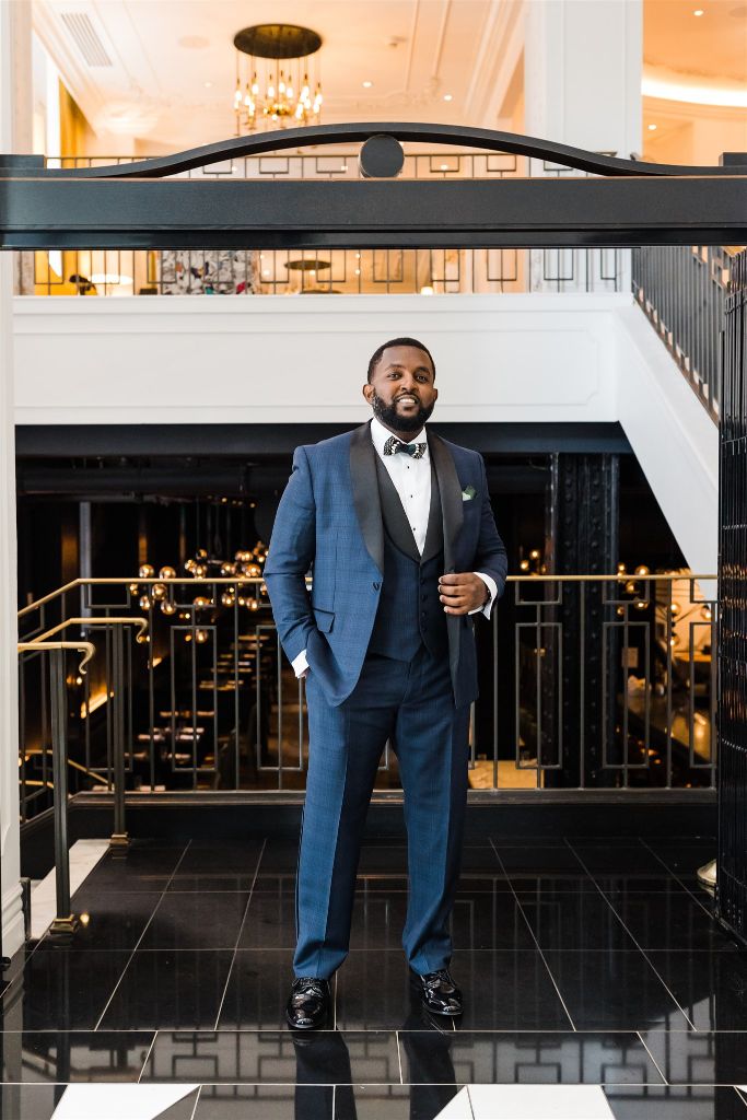 Groom smiles in navy tux at the Hotel Monaco Pittsburgh
