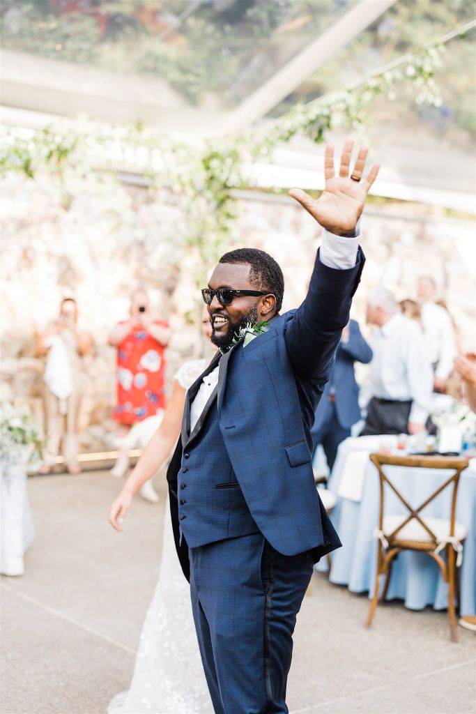 Groom waves to guests at Stables at Hartwood Wedding