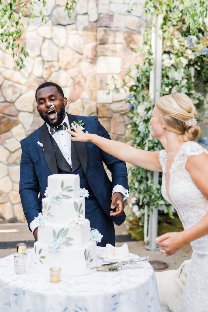 Bride throws icing at groom during cake cutting at Stables at Hartwood Wedding