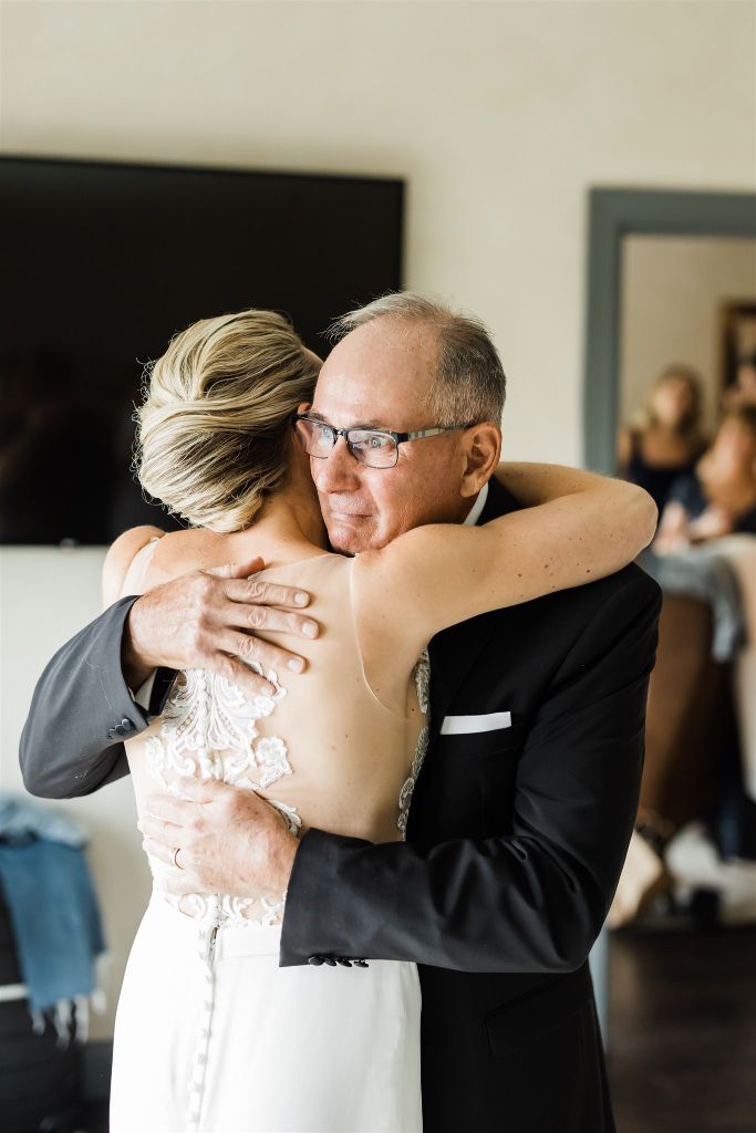 Bride hugs her father as he holds back tears after seeing her for the first time