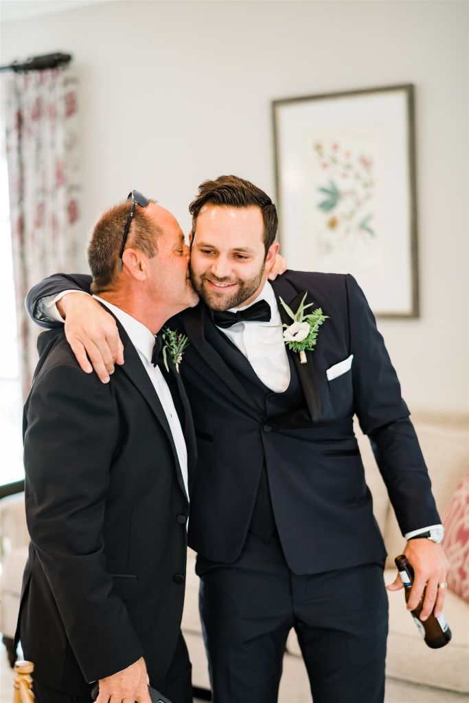 Groom and his father embrace before the ceremony