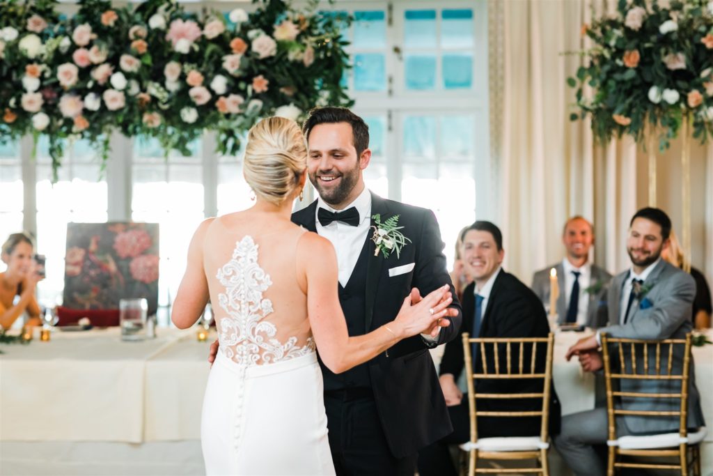 The bride and groom smile as they share their first dance