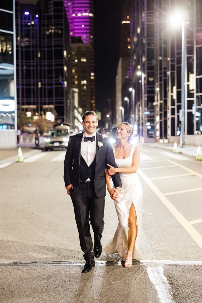 Bride and groom walk together outside PPG Wintergarden