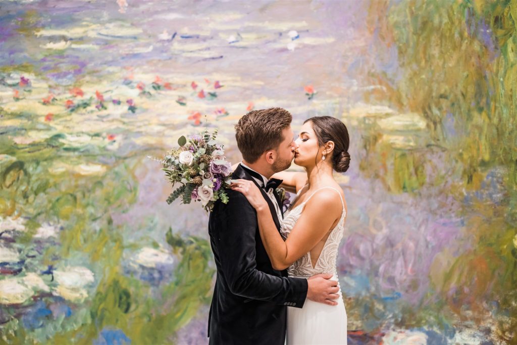 bride and groom kiss in front of a Waterlily Panel at the Carnegie Music Hall Foyer