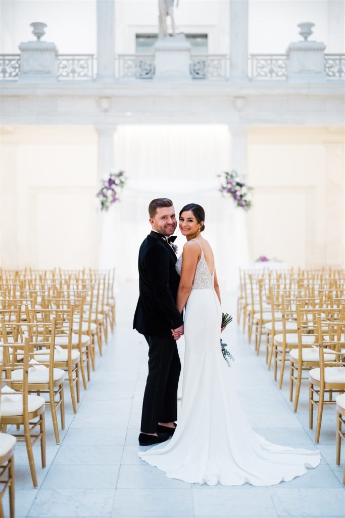 bride and groom pose in the Carnegie Museum Hall of Architecture