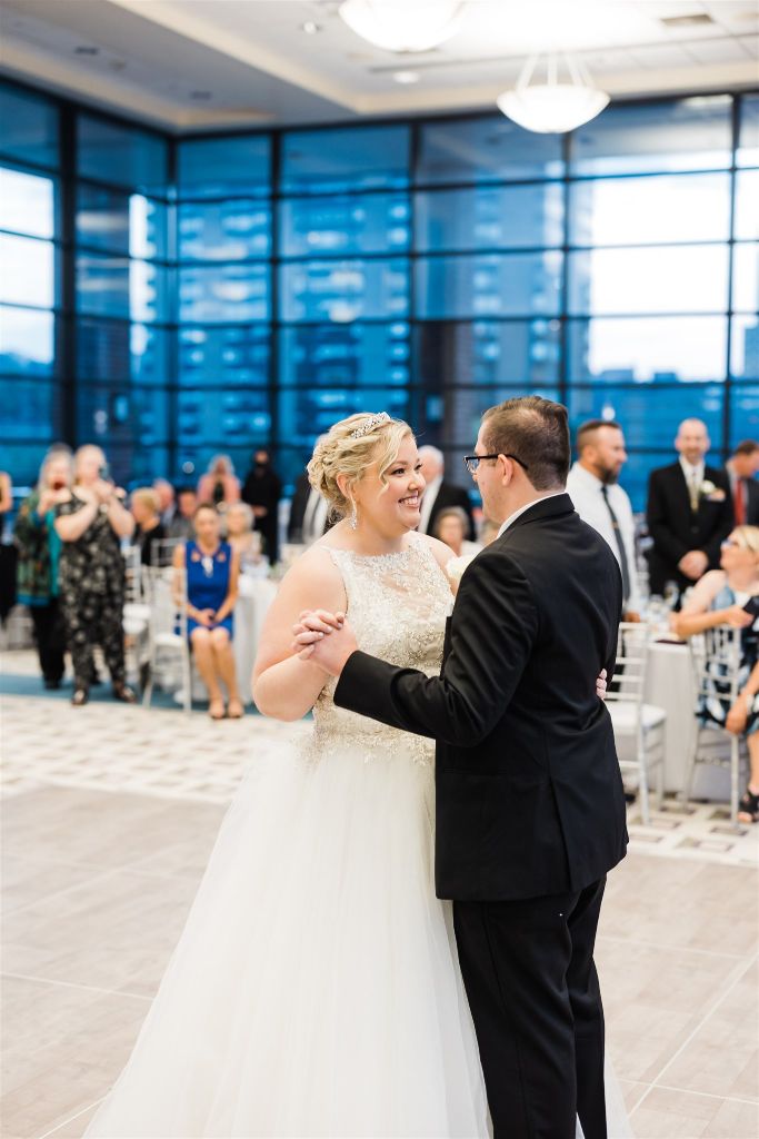Bride and groom smile as they share their first dance