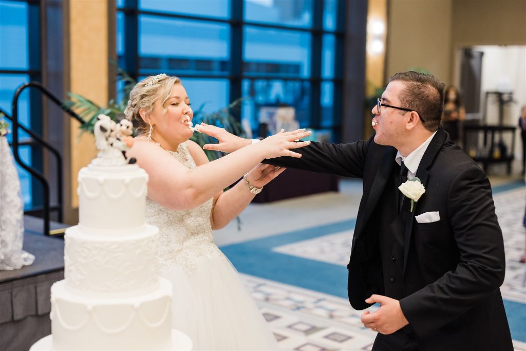 Bride and groom smash their cake in each others faces