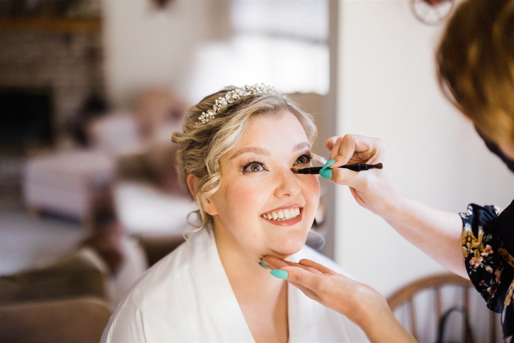 Bride smiles as her make up is applied