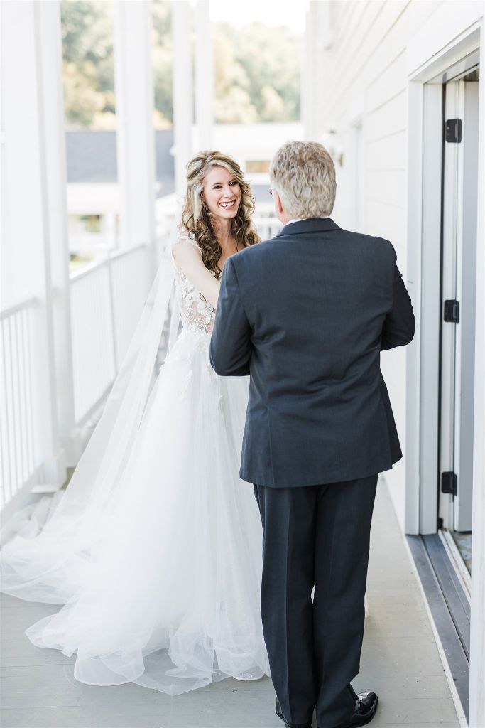 Bride smiles at her father as he sees her for the first time