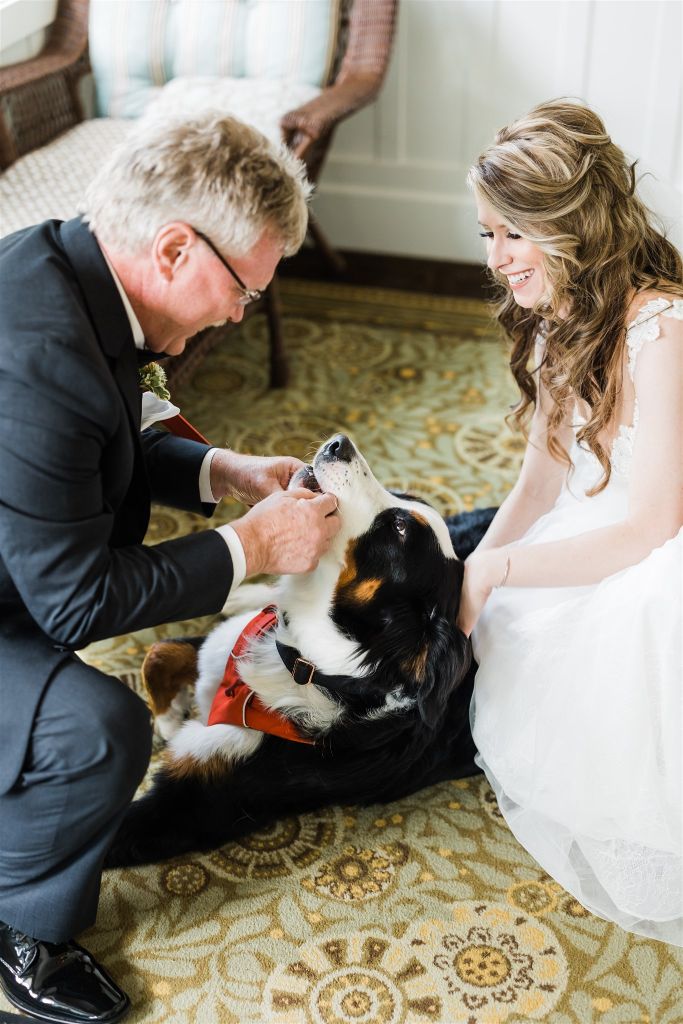 Bride and her father pet their family dog before the wedding begins