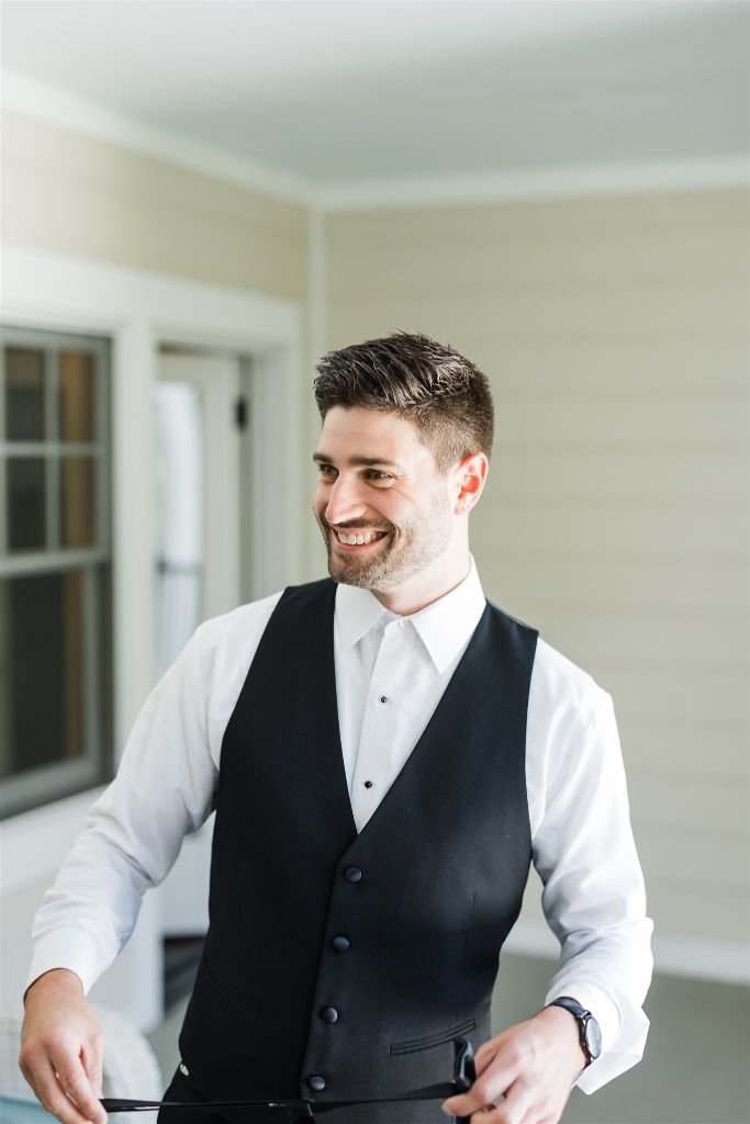 Groom smiles while getting ready for the wedding ceremony