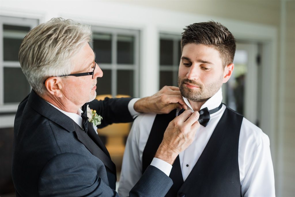 Father of the groom adjusts his bowtie