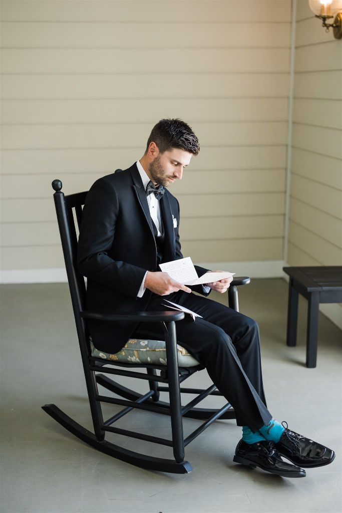 Groom sits on the porch and reads a love letter from the bride