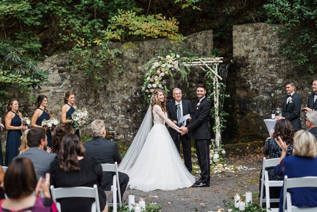 Bride and groom smile at their friends and family at their Grotto wedding at Omni Bedford Springs