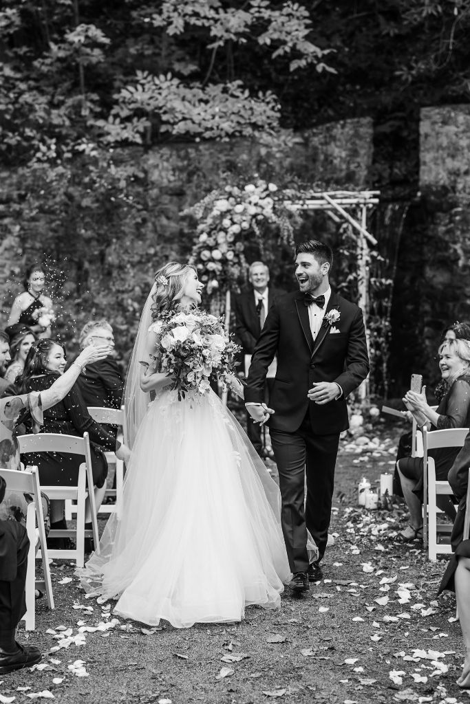 Bride and groom are showered with confetti as they walk up the aisle after their wedding at Bedford Springs grotto