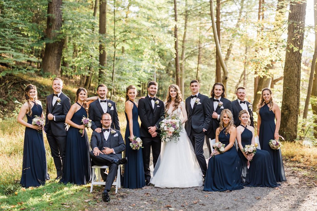 Bridal party poses together near grotto at Omni Bedford Springs hotel