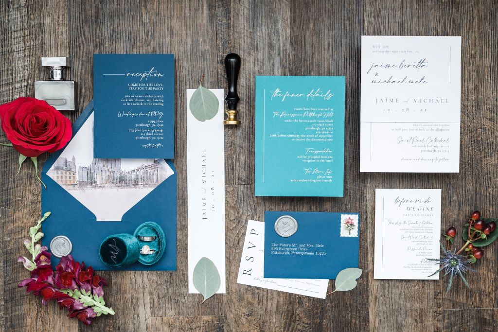 Teal, blue and red lay flat details with stationery, perfume and jewelry