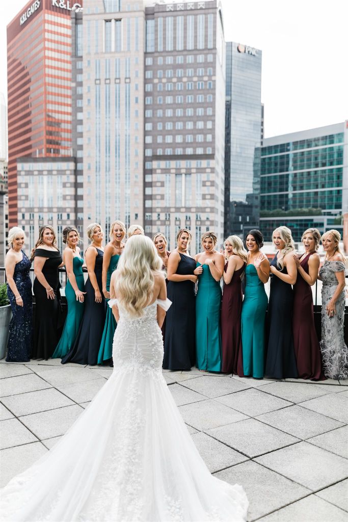 Bridesmaids joyfully react to seeing bride for the first time