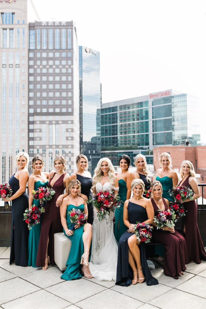 Bride and bridesmaids pose together and smile into the camera