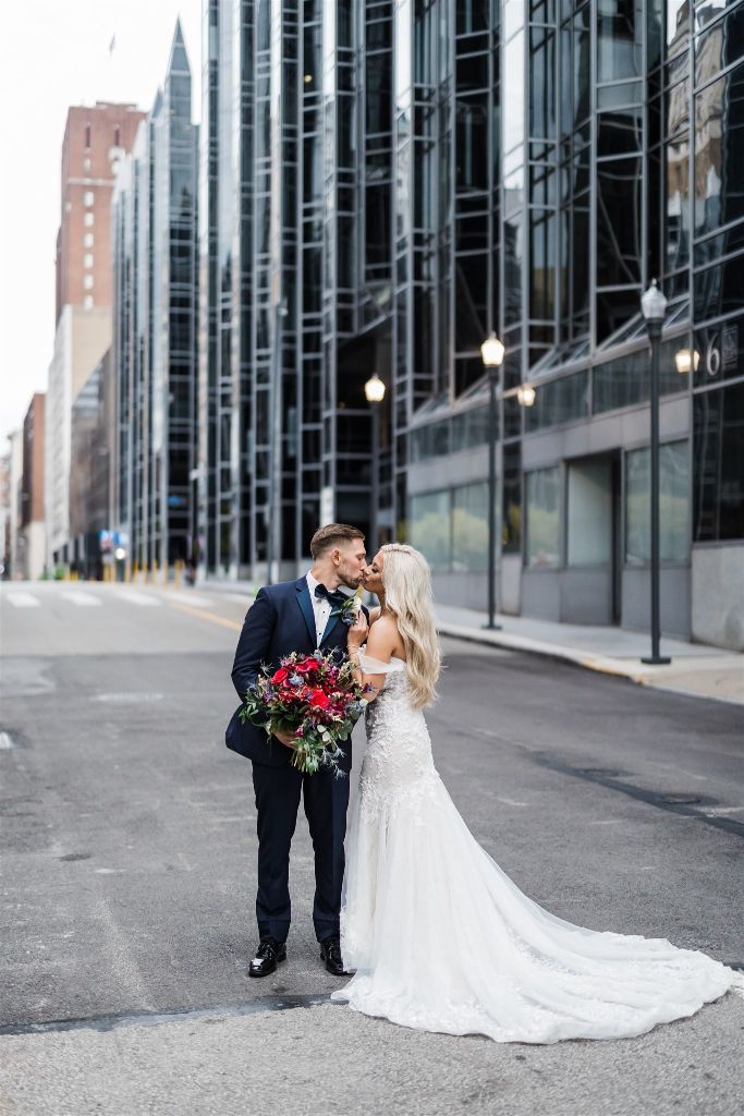 Bride and groom kiss in front of PPG Wintergarden 