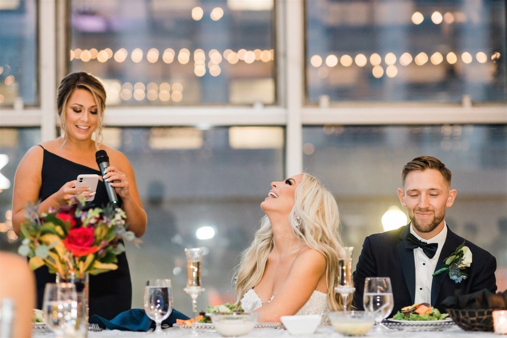 Bride and groom laugh during speeches during reception at Wedding at PPG Wintergarden