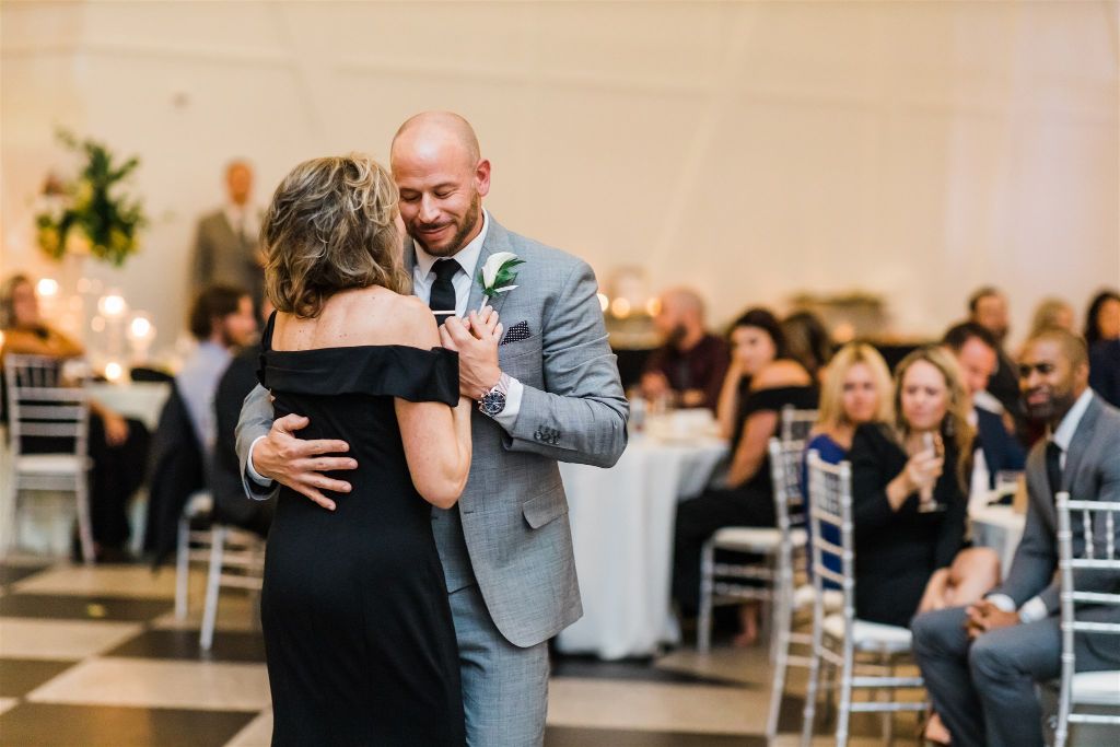 Groom hugs mother at PPG Wintergarden Full Glam Downtown Wedding reception