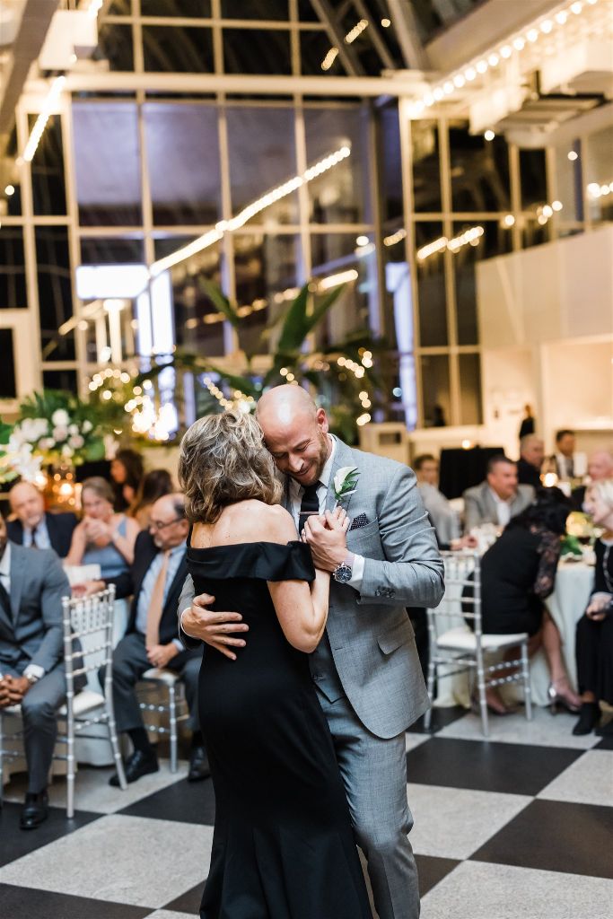 Groom hugs mother at PPG Wintergarden Full Glam Downtown Wedding reception