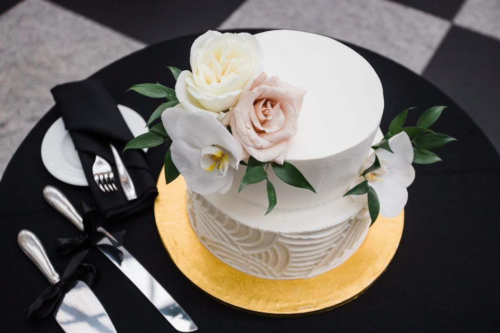 Two tiered white wedding cake on a black linen