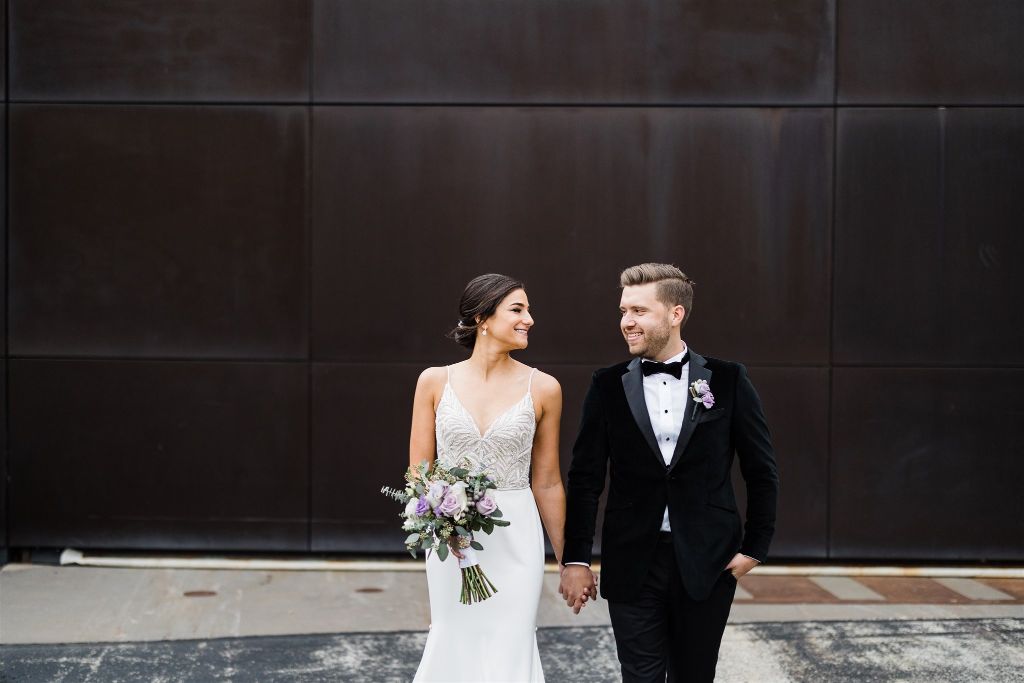 Bride and groom pose together outside Carnegie Museum 