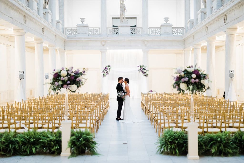Bride and groom pose together in ceremony space at Jewish wedding at the Carnegie