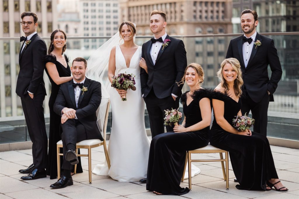 Bride, groom and bridal party pose together on the roof top of the Hotel Monaco