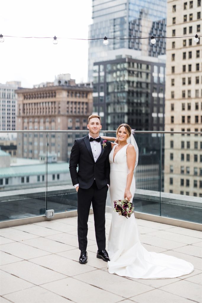 Bride and groom pose together on the rooftop of the Hotel Monaco