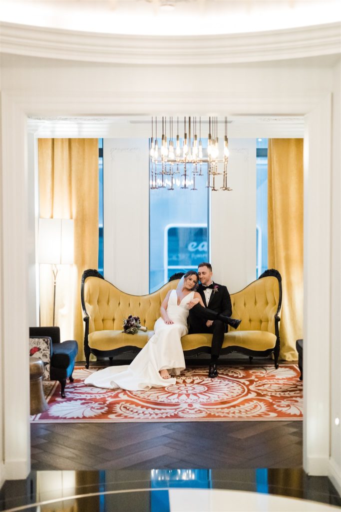 Bride and groom sit together in the lobby of the Hotel Monaco in Pittsburgh 
