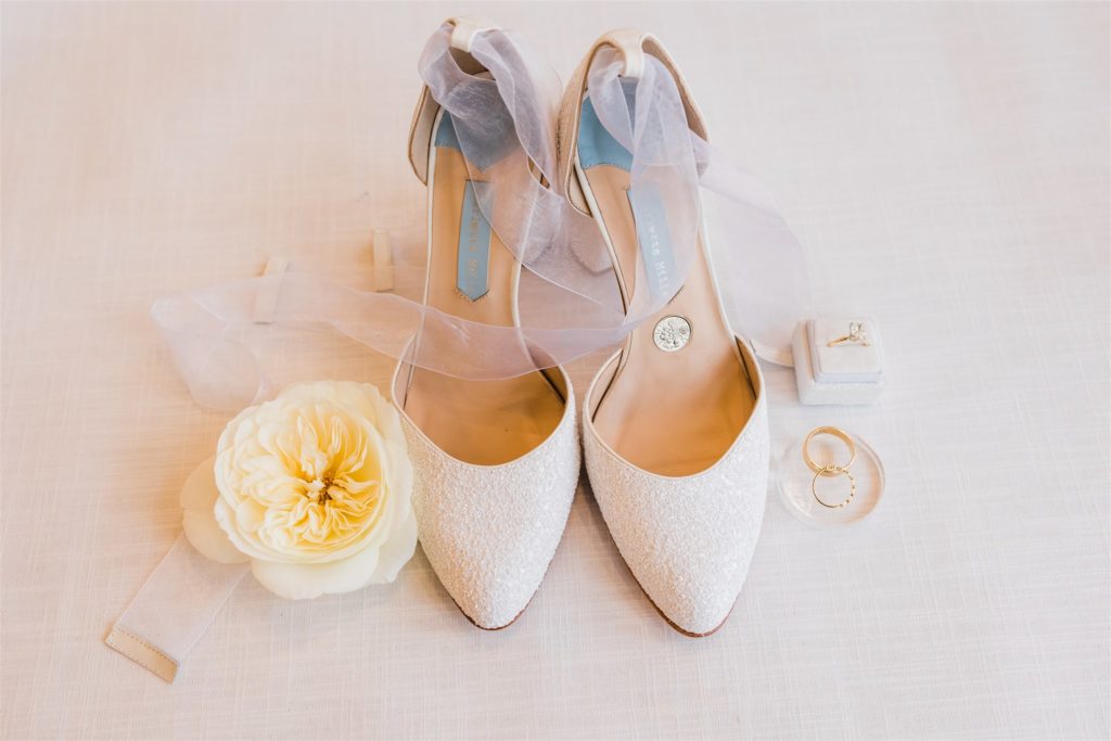 Wedding shoes with wedding bands and white florals