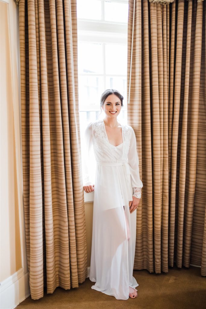 Bride poses at Mansions on Fifth in white wedding robe