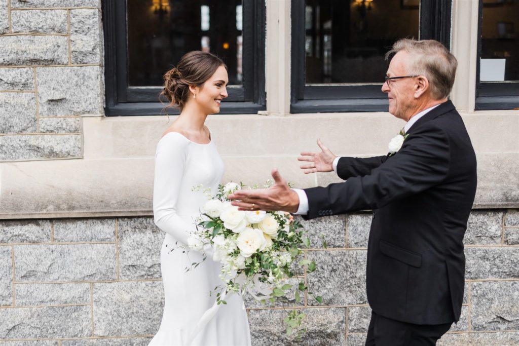 Father of the bride hugs her after seeing her in her gown for the first time